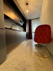 a kitchen with a red chair in a room at Dream Studios 2 in Bucharest +11 photos