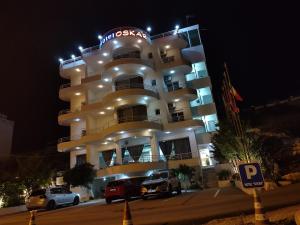 a large white building with cars parked in front of it at Oskar Hotel in Sarand&euml;