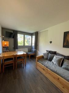 una sala de estar con un sofá y una mesa en Les Mélèzes, en Saint-Chaffrey