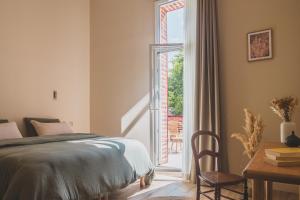 a bedroom with a bed and a sliding glass door at Maison Montaut in Onesse-et-Laharie