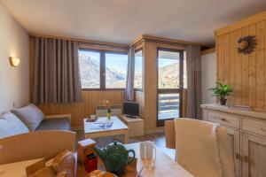 una sala de estar con un sofá y una mesa en Les Mélèzes, en Saint-Chaffrey