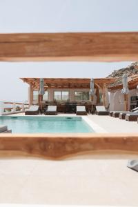 a swimming pool in a resort with lounge chairs at Naxos Earth Suites in Mikri Vigla