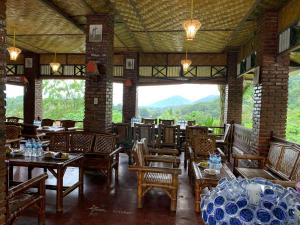 a restaurant with tables and chairs and a large window at Sama Sama Homestay & Trekking Only Stay Here Book Trekking and Transport With Us in Bukit Lawang