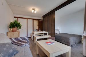 Una sala de estar con un sofá, una cama y una mesa. en Les Mélèzes, en Saint-Chaffrey