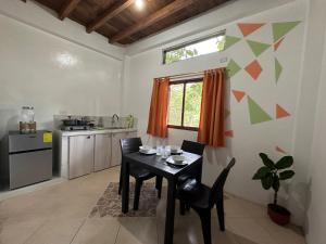 a kitchen with a table and chairs in a room at Hostal Casa Taisha in Montañita
