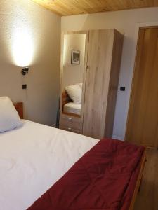 - une chambre avec un lit et une porte avec un miroir dans l'établissement Le Bois Joli en Chartreuse, à Saint-Pierre-de-Chartreuse 13 autres photos