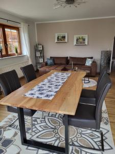 a dining room with a wooden table and chairs at Ferienwohnung Landhaus Reitersbruch in Beckingen
