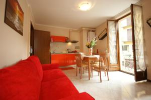 a living room with a red couch and a kitchen at Peter Schubert in Baveno