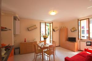 a living room with a table and chairs and a kitchen at Peter Schubert in Baveno