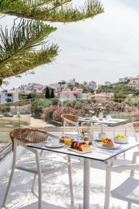 a white table with food on top of a balcony at Aspronissos Hotel in Skiathos