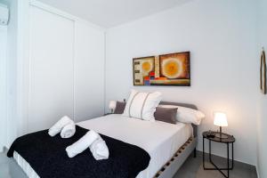 Un dormitorio blanco con dos camas con toallas. en Terrazas de Ladera A2 Luxury by Casasol, en Nerja