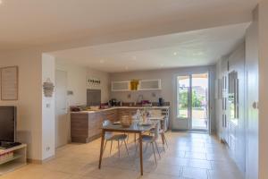 a kitchen with a table and chairs in a room at Logement spacieux agréable in Saint-Privat