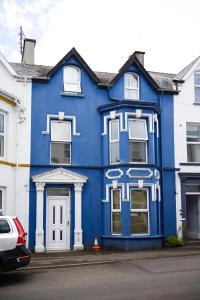 a blue building with white trim on a street at The Blue House in Portrush