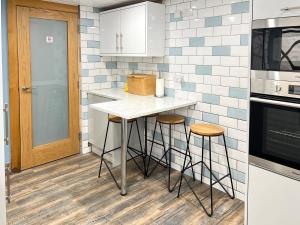 a kitchen with a counter and stools in it at The Blue House in Portrush +14 photos