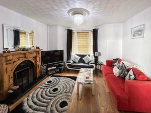 a living room with a red couch and a fireplace at The Blue House in Portrush