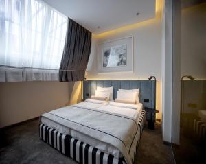 a bedroom with a large bed and a window at Maison Royale in Belgrade