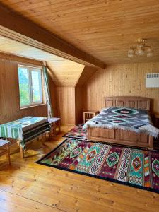 a bedroom with a bed and a rug in a room at Садиба Кичера in Petrashani