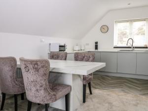 a kitchen with a table and chairs and a sink at Sea View in South Hayling