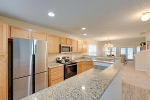 a kitchen with wooden cabinets and a stainless steel refrigerator at Central and Spacious Townhome in Greensboro! in Greensboro
