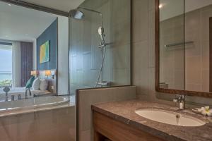 un bagno con un lavandino, uno specchio e una vasca di Grand Liberty a Ấp Lò Vôi