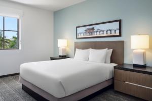 a bedroom with a large white bed and two lamps at Hyatt House Naples 5th Avenue in Naples