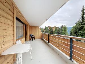 a balcony with a bench and a table on it at Cimerose 1 in Verbier
