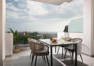 una sala da pranzo con tavolo e sedie su un balcone di Twins Yard a Nikiti