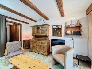 a living room with a table and a chair and a piano at Cimerose 1 in Verbier