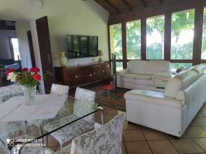 a living room with white furniture and a glass table at La Rosa Selvatica in Ravarino