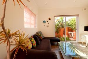- un salon avec un canapé et un sol en verre dans l'établissement Surfhostel Cape Town, au Cap