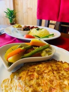two plates of food on a red table at Golden King Guest in Nuwara Eliya