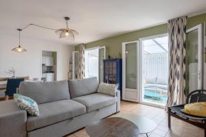 a living room with a couch and a table at Maison Avec Jardin 400m Du Centre in La Tranche-sur-Mer