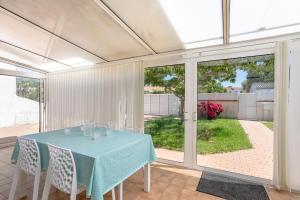 a dining room with a blue table and chairs at Maison Avec Jardin 400m Du Centre in La Tranche-sur-Mer