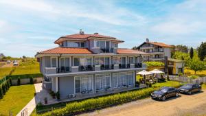 a house with two cars parked in front of it at La Mansión in Lozenets