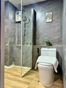 a bathroom with a shower and a white toilet at Best LD Hotel โรงแรมเบส แอลดี in Hua Hin +50 photos