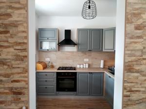 a kitchen with gray cabinets and a stove at Tone in Ogulin +20 photos