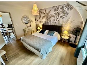 une chambre avec un grand lit avec un tableau au mur dans l'établissement Le Duplex ou l'Appart d'Agnès", à Honfleur