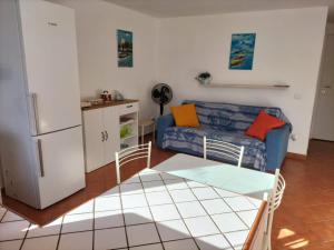 een woonkamer met een blauwe bank en een koelkast bij Green Space Apartment in Mondello