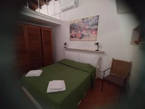 een slaapkamer met een groen bed en een stoel bij Green Space Apartment in Mondello