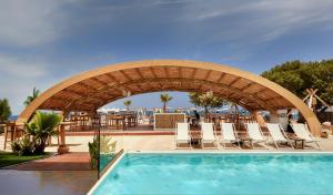 een zwembad in een resort met stoelen en tafels bij Enorme Teatro Beach in Amoudara Herakliou