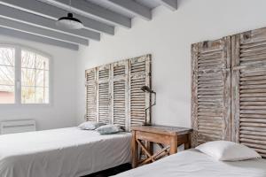 two beds in a room with white walls and a window at Gite Gauriaguet in Gauriaguet +15 photos