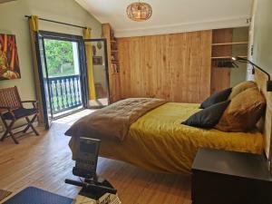 a bedroom with a bed in a room with a balcony at Fleurs in Bassussarry
