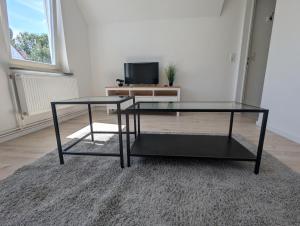 uma mesa de café em vidro numa sala de estar com uma televisão em Wohnung am Fischereihafen Modern & gemütlich em Bremerhaven