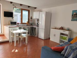 een keuken met een tafel en een witte koelkast bij Green Space Apartment in Mondello +7 foto's