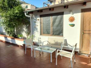 een patio met 2 stoelen en een glazen tafel bij Green Space Apartment in Mondello