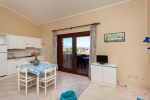 eine Küche und ein Esszimmer mit einem Tisch und einem TV in der Unterkunft Sea View - Cozy apartment with parking space in San Teodoro