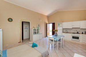 eine Küche und ein Esszimmer mit Tisch und Stühlen in der Unterkunft Sea View - Cozy apartment with parking space in San Teodoro + 17 Fotos