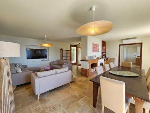 a living room with a table and a dining room at Villa prestige avec piscine - dans les hauteurs de Bastia in Bastia