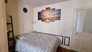 a bedroom with a bed and a picture on the wall at Chez Sophie, cosy et calme, à deux pas de Paris in Saint-Mandé