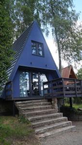a blue house with stairs leading up to it at Domek nad Jeziorem Kaszuby max 6 os in Bieszkowice